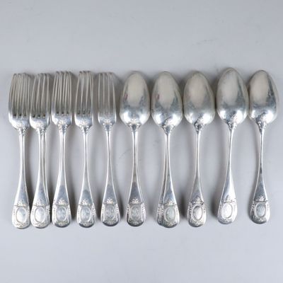 six cuillères et six fourchettes sur une table blanche