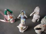 five figurines of children sitting on a table