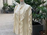 un mannequin devant un immeuble, avec un arbre en arrière-plan