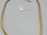 a gold rope necklace with a tag on it