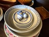 several plates and bowls are stacked on a wooden table