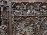 carved wood panel of a nativity scene on a stone wall