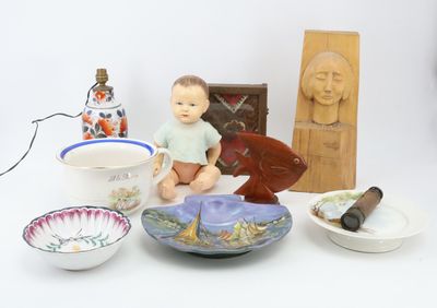 a small doll sitting on a table next to bowls and other items