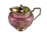 a pink and gold teapot on a white background