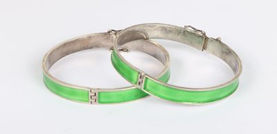 a pair of green enamel bangles with silver clasps