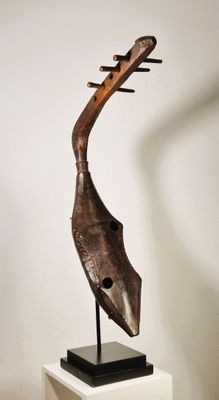statue d'un oiseau en bois posée sur un socle dans une pièce