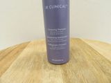 a picture of a bottle of shampooe sitting on a wooden table
