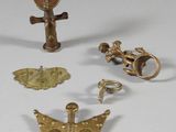 several pieces of gold are displayed on a white surface