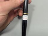 a hand holding a pen with a sticker on it
