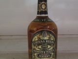 une bouteille de whisky posée sur une étagère devant une fenêtre