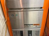 un réfrigérateur argenté et orange dans un coin de la pièce