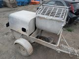 a small cement mixer on a trailer in a parking lot