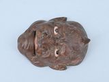 une petite statue représentant un chien couché par terre