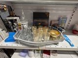 un plateau en argent sur lequel se trouvent des verres et une bouteille