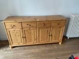 a wooden cabinet in a room with a radiator in the background