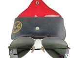 une paire de lunettes de soleil avec un étui rouge et un chapeau rouge sur fond blanc