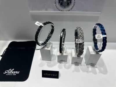 trois bracelets et un sac sont posés sur une table, à côté d'un sac noir