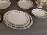 many plates and bowls on the table with flowers on them