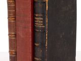 trois vieux livres sont empilés sur une table