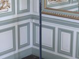 un pied métallique surmonté d'un miroir dans une pièce