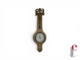 une horloge accrochée au mur et surmontée d'une couronne