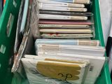 a green box full of books and a pair of scissors