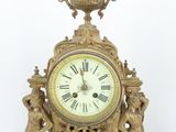 a gold clock that is sitting on top of a table