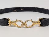 two black belts with gold clasps on them on a white surface