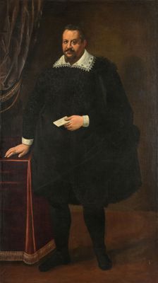 portrait of a man in a black coat and white collar holding a book