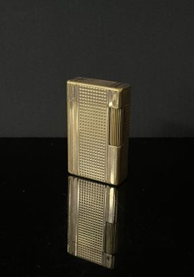 DUPONT Briquet en métal doré. Signature au revers.