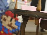 a small wooden table with a pink plate on top of it