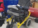 a wheelchair that is sitting in a warehouse with other chairs