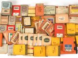 de nombreux paquets de cigarettes et des cigarettes posés sur une surface blanche
