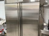 a stainless steel refrigerator in a kitchen with a microwave on the counter