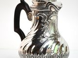 a silver pitcher that is sitting on a table