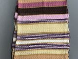 a multicolored striped blanket hanging on a wall
