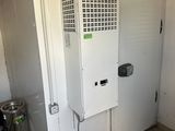 a white refrigerator in the corner of a room next to a trash can