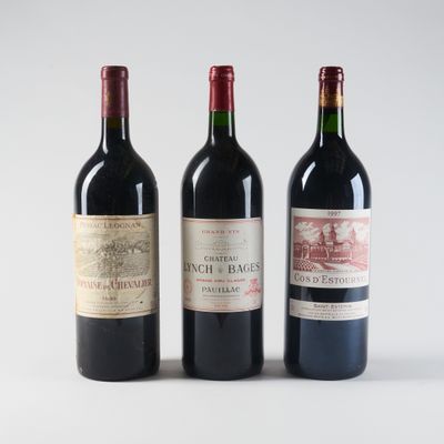 three bottles of red wine are lined up on a white surface