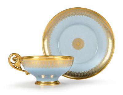 tasse et soucoupe dorées et bleues sur fond blanc