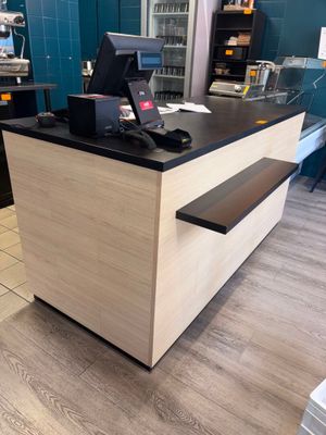 un petit comptoir sur lequel est posé un ordinateur portable, dans un magasin