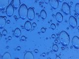 a close up of water droplets on a blue surface