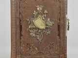 un vieux livre orné d'un motif décoratif, posé sur une surface blanche