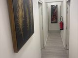a picture of a long hallway with paintings on the wall
