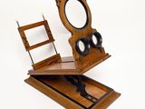 a mirror and a wooden chair on a white surface