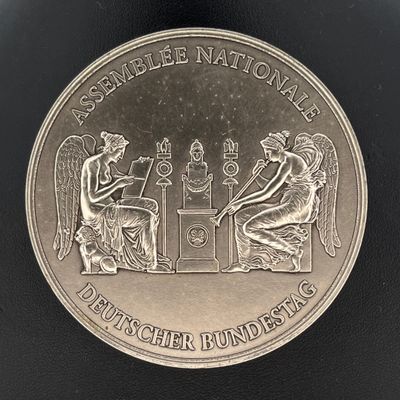 l'image d'une pièce d'argent sur laquelle figurent un homme et une femme assis à une table