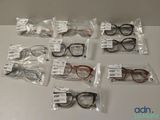 several pairs of eyeglasses are in plastic bags on a table