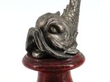 sculpture en bronze représentant un oiseau sur un socle, sur fond blanc