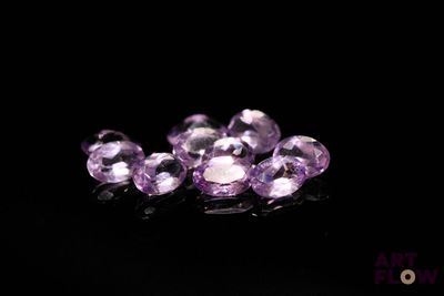 de très jolies pierres précieuses violettes sur un fond noir