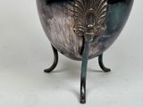 a large silver bowl with a handle on a stand
