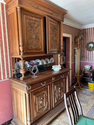 a wooden china cabinet in the middle of a dining room